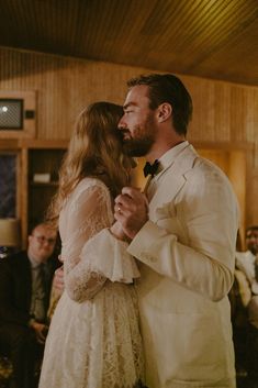 a bride and groom sharing a kiss in front of an audience at their wedding reception