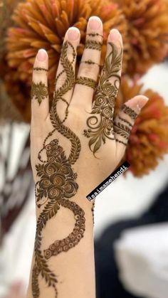 a woman's hand with henna tattoos on it