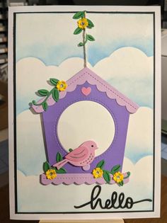 a handmade card with a birdhouse and flowers on the front, which reads hello