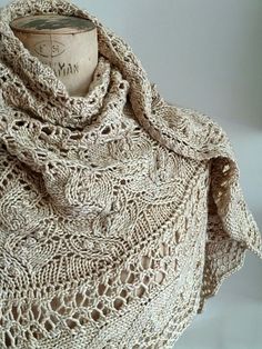 a knitted shawl is shown on a mannequin