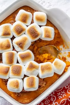 a casserole dish with marshmallows in it and a spoon on the side