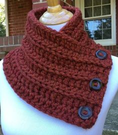 a close up of a scarf on a mannequin with buttons in front of a brick building