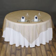 two white plates on top of a round table