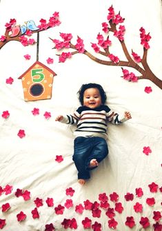 a baby laying on top of a bed covered in flowers