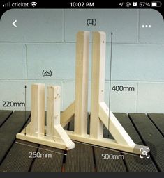 a wooden stand with measurements for the top and bottom legs, on a wood table