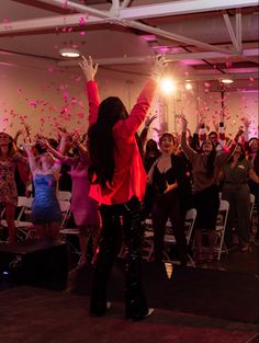 a group of people in a room with pink confetti