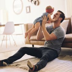 a man sitting on the floor holding a small child