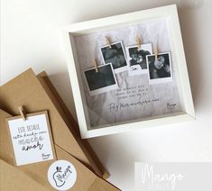 an open box with pictures hanging on clothes pins next to a brown envelope and some other items