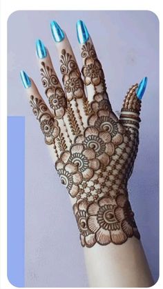 a woman's hand with henna on it and blue nail polishes in the middle