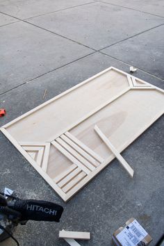 a motorcycle parked next to a large wooden frame on the ground with tools nearby and another bike in front of it