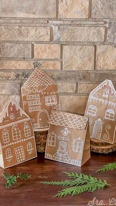 three gingerbread houses made out of brown paper