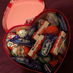 an open heart shaped box filled with candy