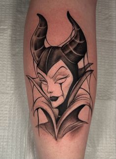 the tattoo on this woman's leg shows her face and horns