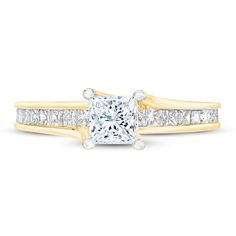 a princess cut diamond ring with channel set diamonds on the band and side stones in yellow gold