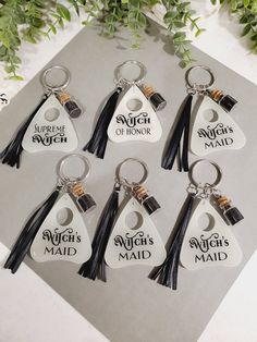 six keychains with the words, witch maid and seven brooms on them