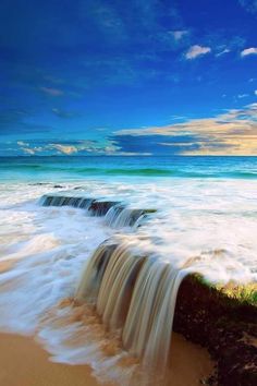 the water is flowing over the rocks into the ocean