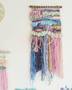 there is a wall hanging made out of yarn and beads