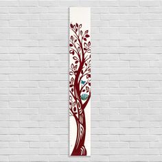 a white brick wall with a red tree painted on it's side and the words, love is in the center