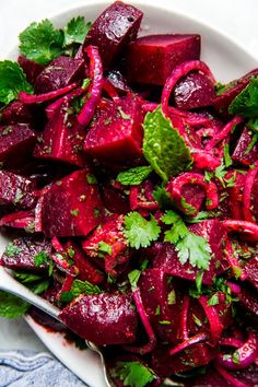 a white plate topped with beets and cilantro