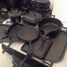 an assortment of cast iron pans and skillets