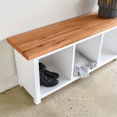 a pair of black shoes sitting on top of a white shelf next to a potted plant