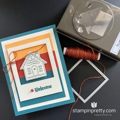 an open box with a spool of thread next to it and a card that says welcome