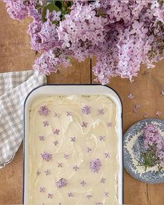 a cake with white frosting and purple flowers