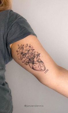 a woman's arm with a heart and flowers tattoo on the left inner arm