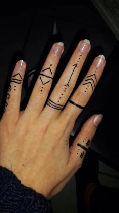 a woman's hand with two finger tattoos on her left and the other one has arrows