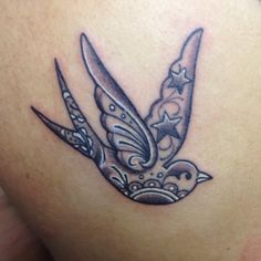 a tattoo on the back of a woman's shoulder with two scissors and a bird