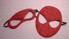 two pieces of red fabric with spiderman masks cut out to look like they are on the floor