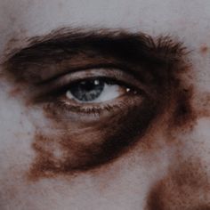 a close up of a man's face with brown paint on it