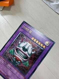 a purple card with an evil clown face on it's front and back cover