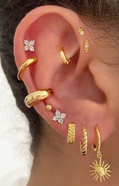 an ear with five different types of piercings on the top and bottom of it