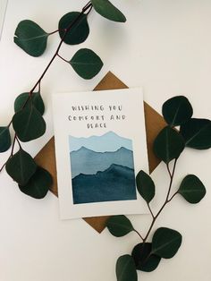 a card with the words wishing you comfort and peace on it next to some leaves