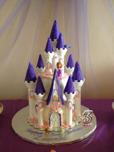 there is a cake that looks like a castle on top of a purple table cloth