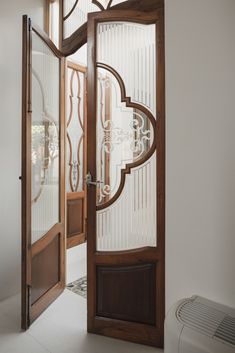 an open wooden door with glass panels on the front and side doors, in a white room