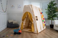 a child's play tent in the corner of a room with toys on the floor