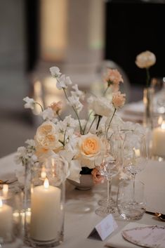 a table topped with lots of white flowers and candles