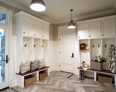 a hallway with white cabinets and wooden benches