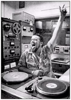 a man with his hands up in front of an old record player