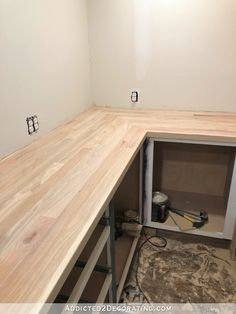 an unfinished kitchen counter being built in the middle of a room with white walls and wood flooring