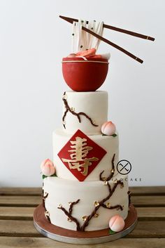 a three tiered cake with chopsticks on top