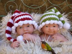 two baby dolls wearing knitted hats and scarves