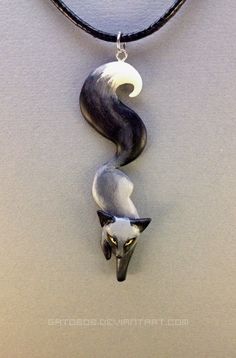 a black and white necklace with an animal on it