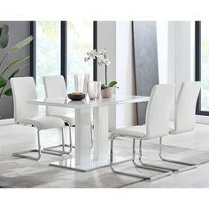 a white dining table and chairs in a room