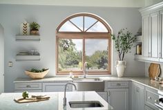 a kitchen with an arched window over the sink