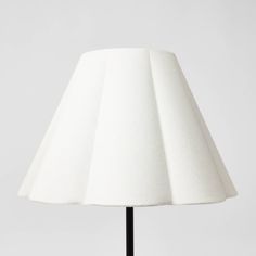 a white lamp with a black base on a table