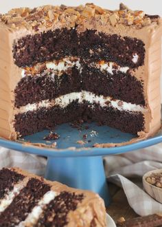 a chocolate cake with white frosting and walnuts on top is cut in half