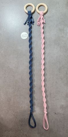 two crocheted handles are attached to each other on a gray surface with a white tag hanging from the end